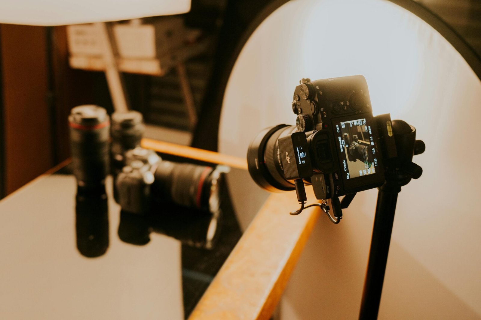 Close-up of a professional photography setup with cameras and lenses under studio lighting.